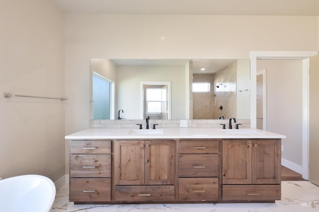 bathroom with marble finish floor, double vanity, a sink, and a shower stall