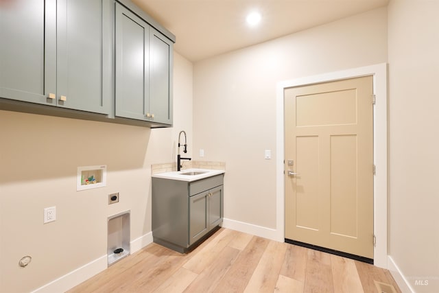 laundry area with washer hookup, cabinet space, light wood-style flooring, a sink, and electric dryer hookup