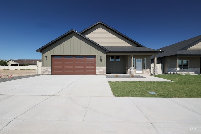 view of front of house with a garage, stone siding, a front lawn, and concrete driveway