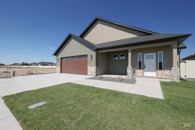 view of front of home featuring a garage, stone siding, a porch, and board and batten siding