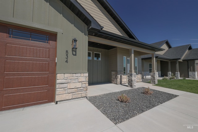 doorway to property with stone siding and covered porch