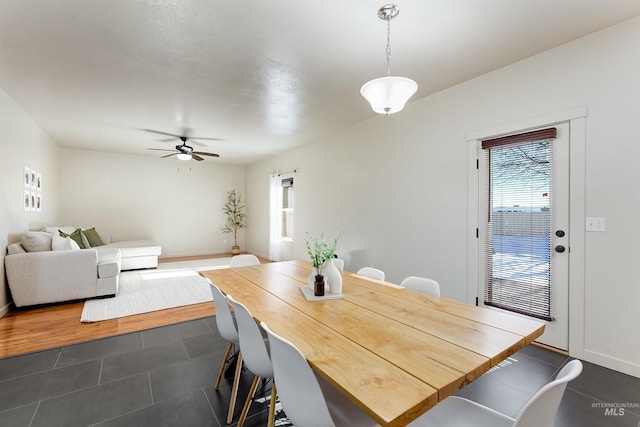 dining area with ceiling fan, plenty of natural light, and dark tile patterned flooring