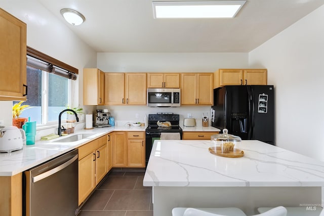 kitchen featuring sink, a breakfast bar, dark tile patterned floors, black appliances, and light brown cabinets