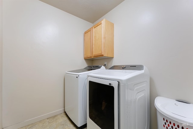 washroom featuring separate washer and dryer and cabinets