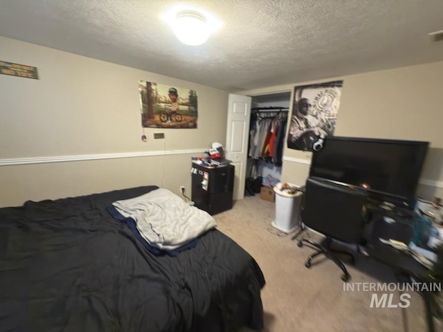 carpeted bedroom with a closet and a textured ceiling