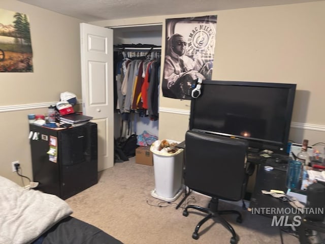 carpeted bedroom featuring fridge and a closet
