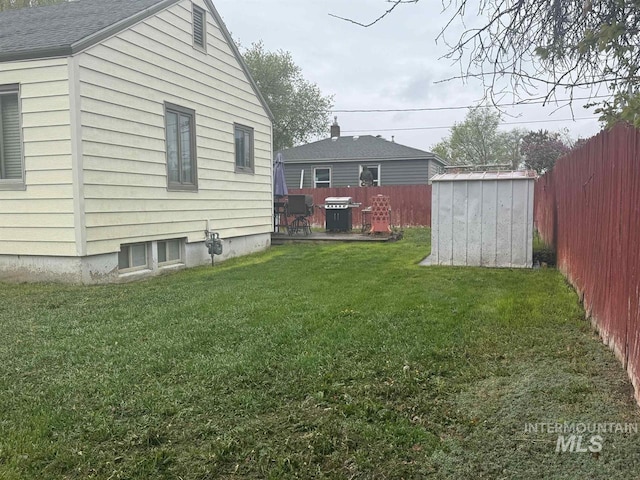 view of yard featuring a storage unit, an outdoor structure, and a fenced backyard