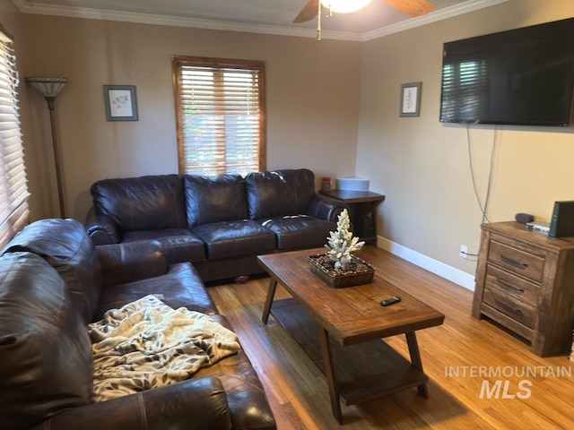 living area with crown molding, baseboards, ceiling fan, and light wood finished floors