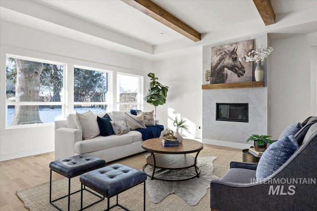 living room with beamed ceiling and light wood-type flooring