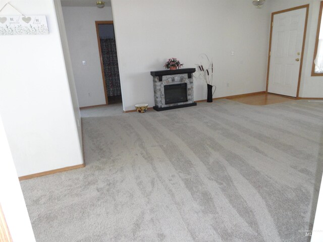 909 W Oakmont Ave, Nampa, ID 83686 - unfurnished living room featuring carpet, a fireplace, and baseboards