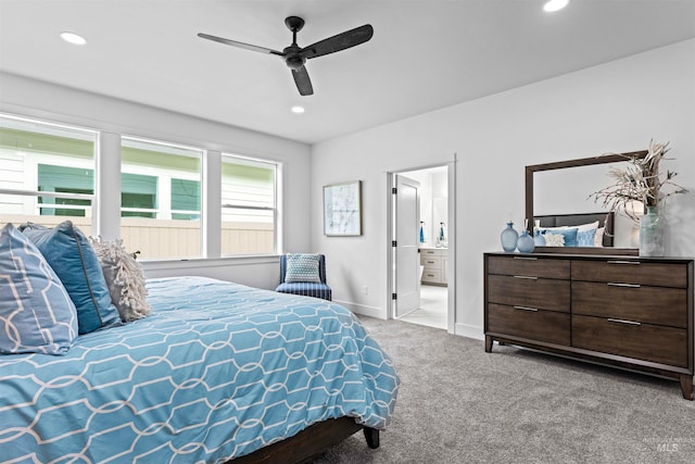 carpeted bedroom with ceiling fan and ensuite bath