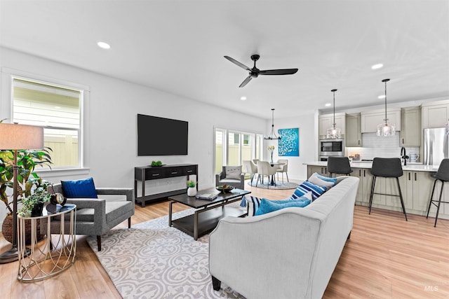 living room featuring light hardwood / wood-style flooring and ceiling fan