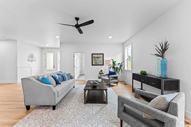 living room with light hardwood / wood-style flooring and ceiling fan