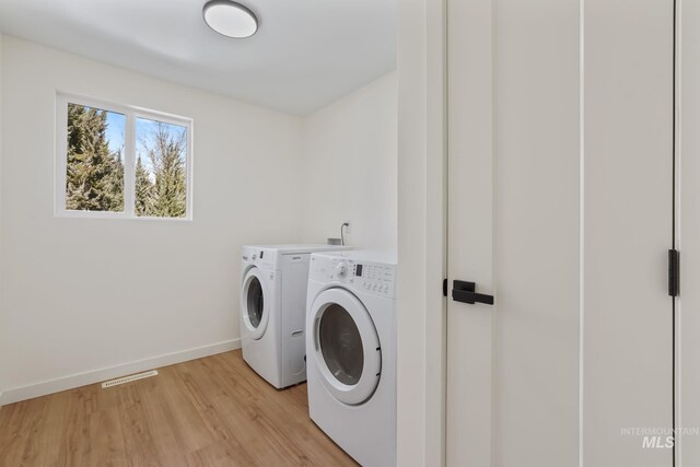22168 Rio Vista Dr, Caldwell, ID 83607 - laundry area featuring visible vents, washing machine and dryer, light wood finished floors, baseboards, and laundry area