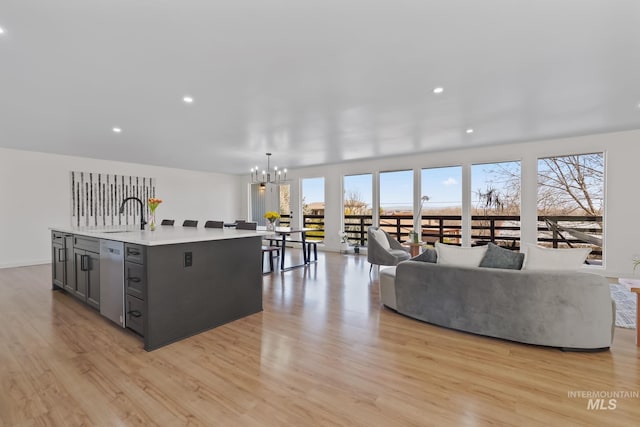 22168 Rio Vista Dr, Caldwell, ID 83607 - kitchen with a sink, light wood-type flooring, gray cabinetry, and an inviting chandelier