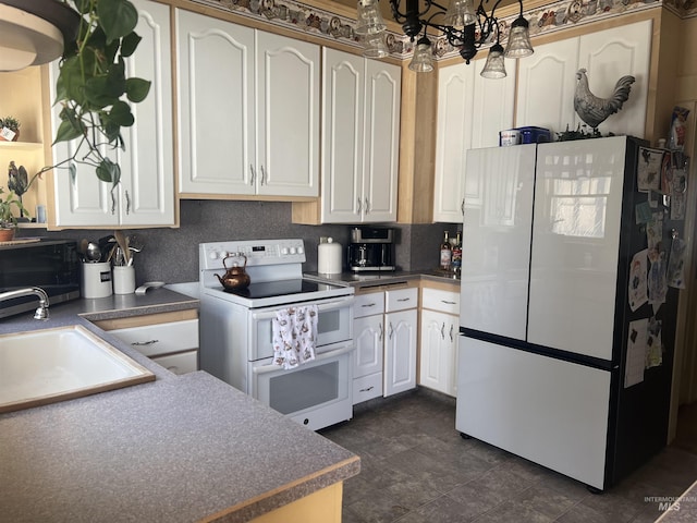 1351 Poplar, Twin Falls, ID 83301 - kitchen featuring white appliances, white cabinets, dark countertops, a chandelier, and decorative backsplash