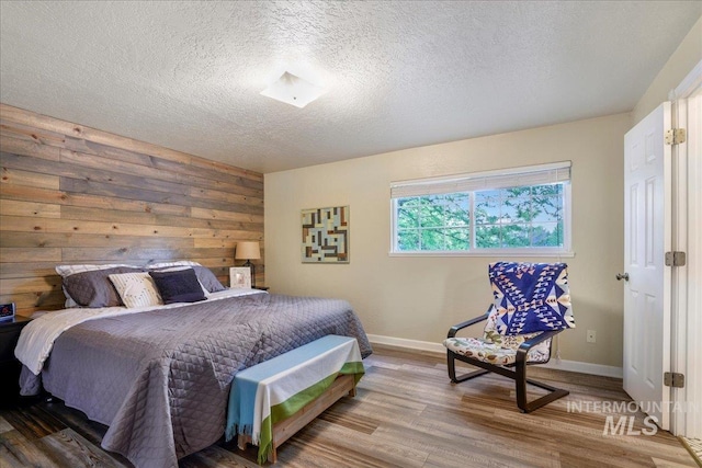 1037 Pahsimeroi Dr, Twin Falls, ID 83301 - bedroom with wood finished floors, baseboards, a textured ceiling, and wood walls