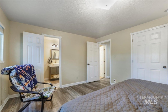 1037 Pahsimeroi Dr, Twin Falls, ID 83301 - bedroom with wood finished floors, baseboards, a sink, and ensuite bath