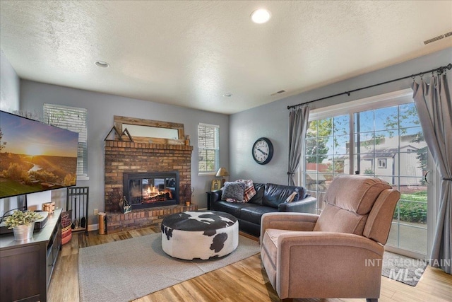 1037 Pahsimeroi Dr, Twin Falls, ID 83301 - living room featuring a textured ceiling, wood finished floors, a brick fireplace, and recessed lighting