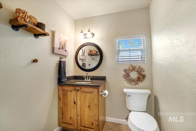 1037 Pahsimeroi Dr, Twin Falls, ID 83301 - bathroom with toilet, vanity, tile patterned floors, a textured wall, and baseboards
