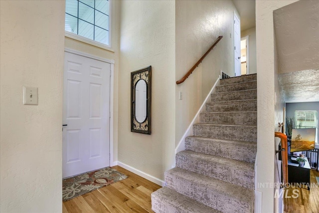 1037 Pahsimeroi Dr, Twin Falls, ID 83301 - foyer entrance with wood finished floors, a textured wall, stairway, and baseboards