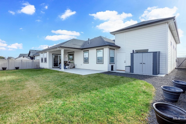 back of house with a lawn and a patio area