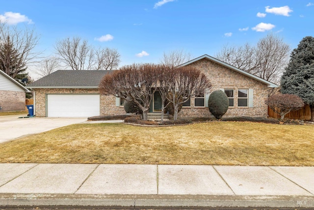 ranch-style home with an attached garage, concrete driveway, brick siding, and a front yard