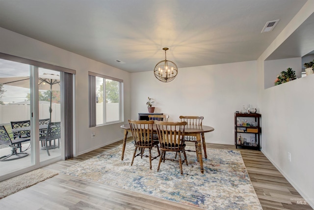 dining area featuring an inviting chandelier and light wood-type flooring