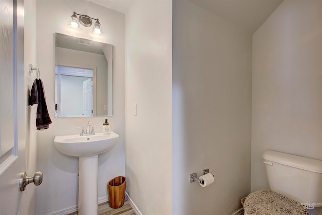 bathroom featuring toilet and wood-type flooring