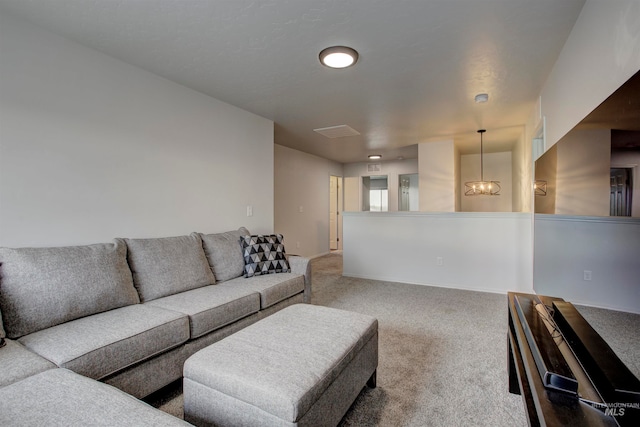 carpeted living room with an inviting chandelier