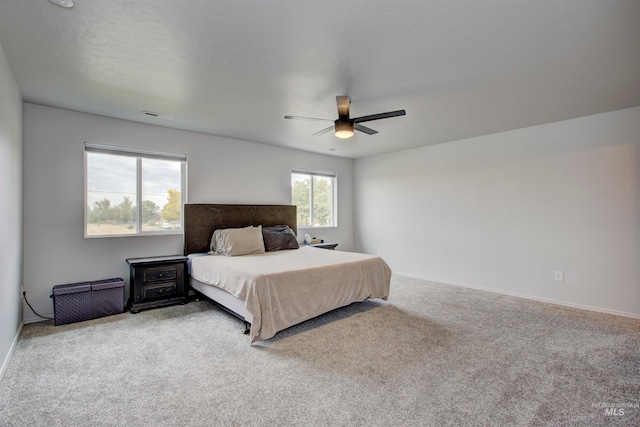 carpeted bedroom featuring multiple windows and ceiling fan