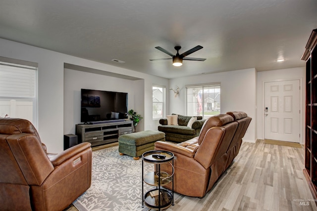 living room with light hardwood / wood-style flooring and ceiling fan