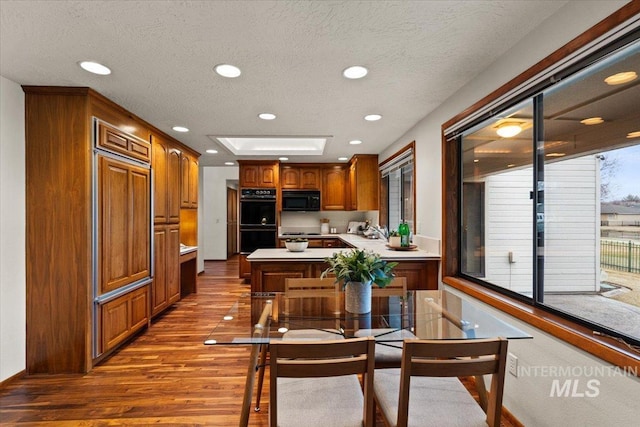 dining area featuring recessed lighting, a textured ceiling, and wood finished floors