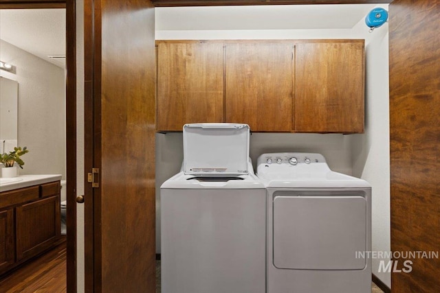 clothes washing area featuring cabinet space and independent washer and dryer