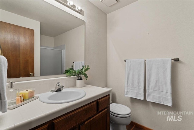 full bathroom with visible vents, toilet, a shower stall, decorative backsplash, and vanity