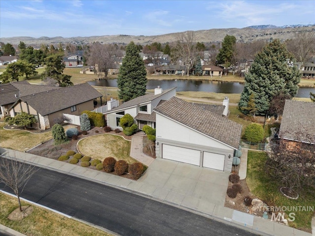 drone / aerial view with a residential view and a water and mountain view