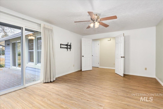 spare room featuring ceiling fan, a textured ceiling, and light wood-type flooring