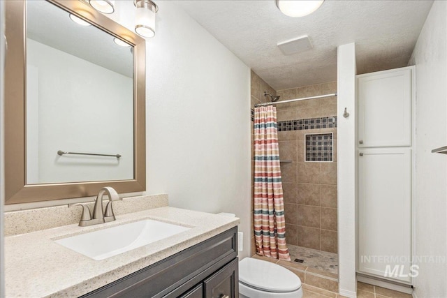 bathroom featuring vanity, toilet, a shower with shower curtain, and a textured ceiling