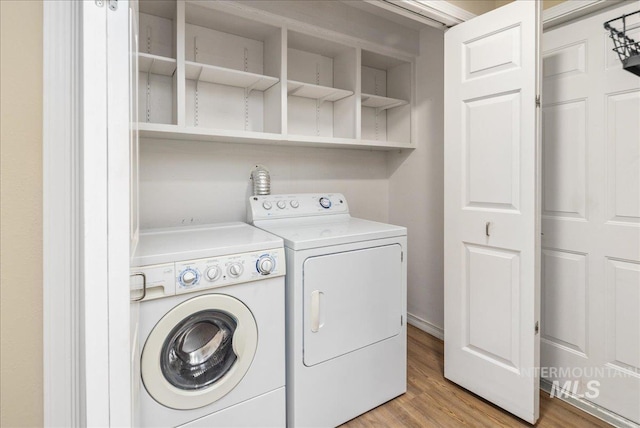 laundry room with light hardwood / wood-style floors and washing machine and clothes dryer