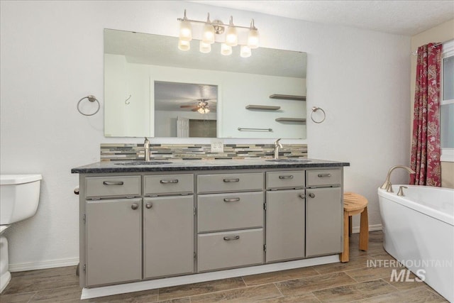 bathroom featuring ceiling fan, vanity, and a bathtub