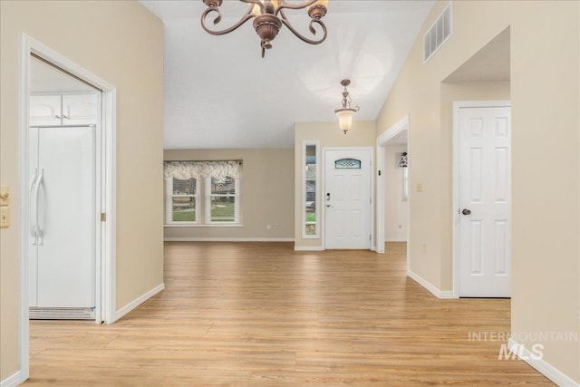 foyer with a chandelier and light wood-type flooring