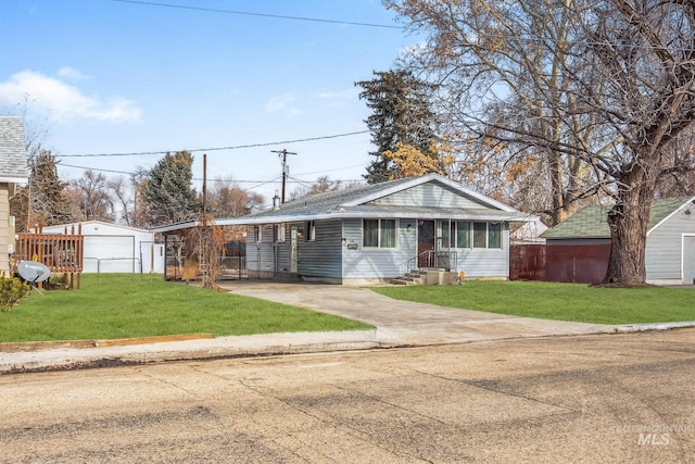 view of front facade featuring a garage, an outdoor structure, and a front lawn