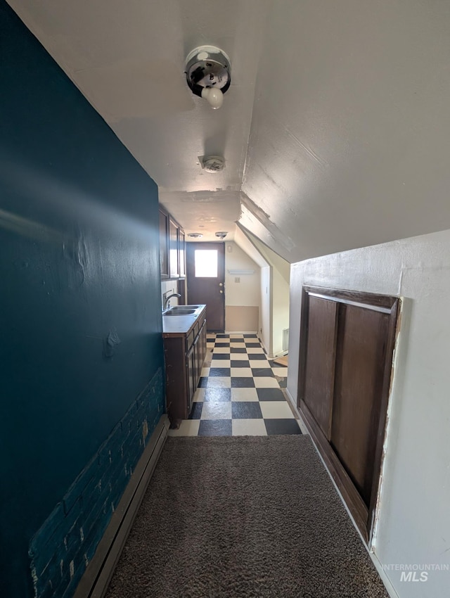 additional living space with tile patterned floors, a sink, and lofted ceiling