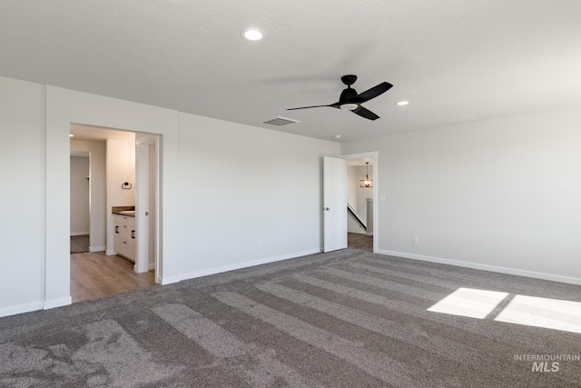 carpeted empty room featuring ceiling fan, a textured ceiling, recessed lighting, visible vents, and baseboards