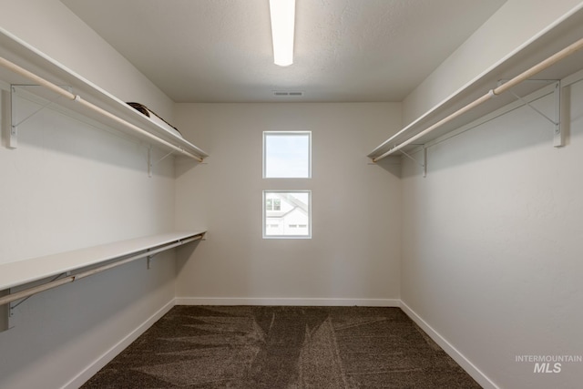 walk in closet featuring dark colored carpet and visible vents