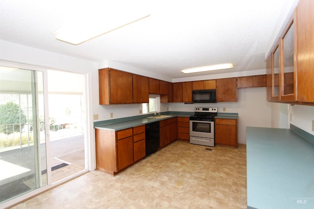 kitchen featuring black appliances, a textured ceiling, and sink