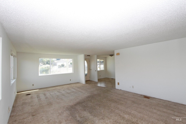 carpeted empty room with a textured ceiling