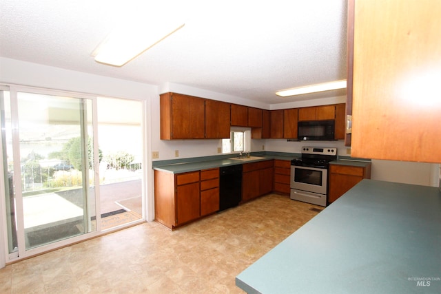 kitchen featuring a textured ceiling, plenty of natural light, sink, and black appliances