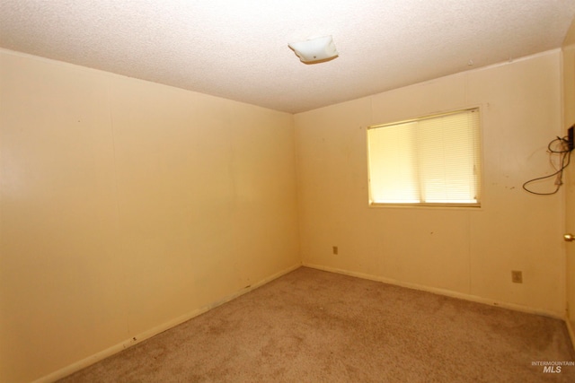 carpeted spare room featuring a textured ceiling