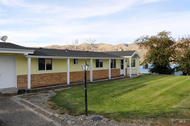 ranch-style house featuring a mountain view and a front lawn